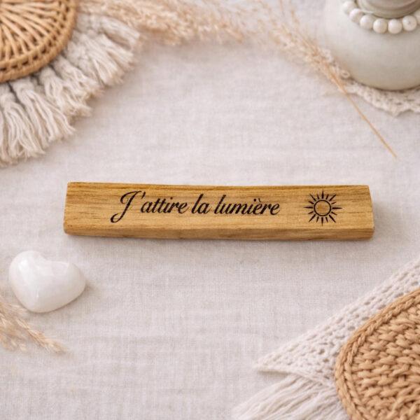 Bâton en Palo Santo gravé du message “J’attire la lumière”, dans une ambiance naturelle et bohème